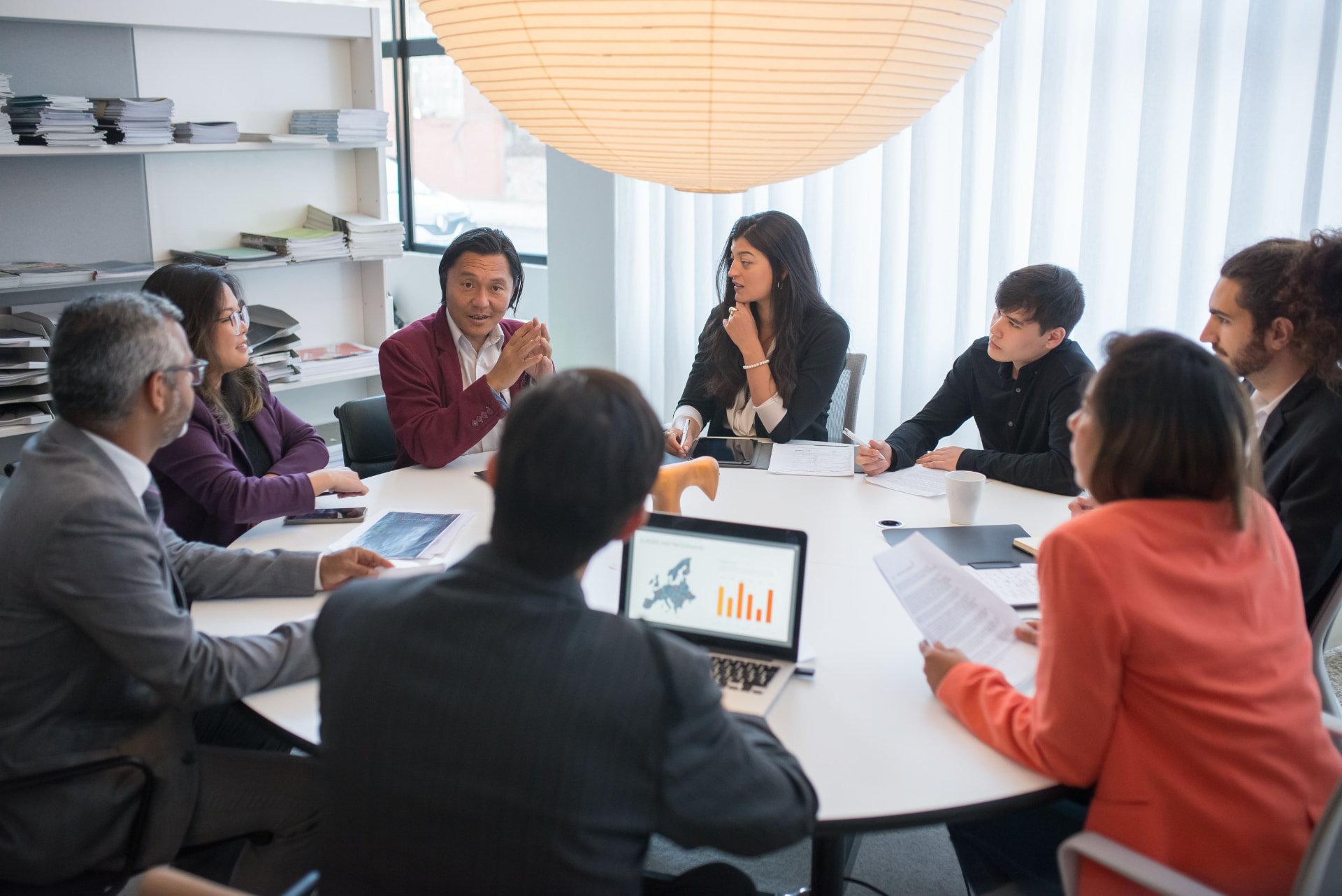 Regulatory and compliance professionals in a team meeting reviewing performance data